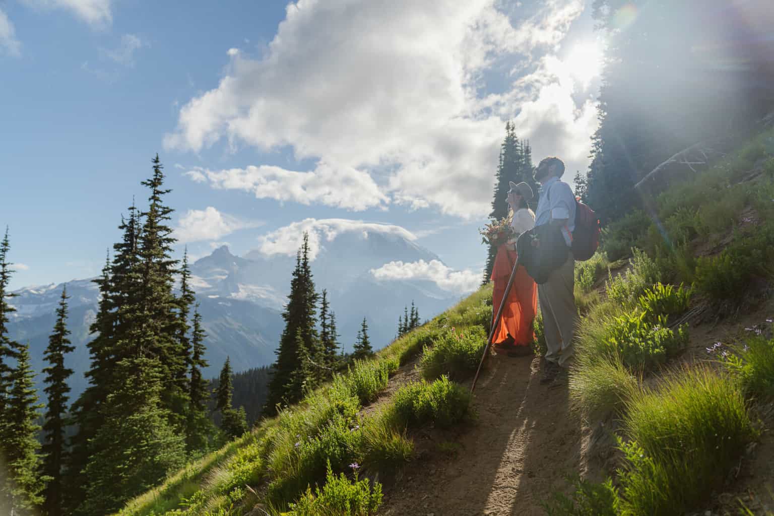 Couple enjoys the view of Mount Rainier as they hike to their vow exchange location with outshined photography