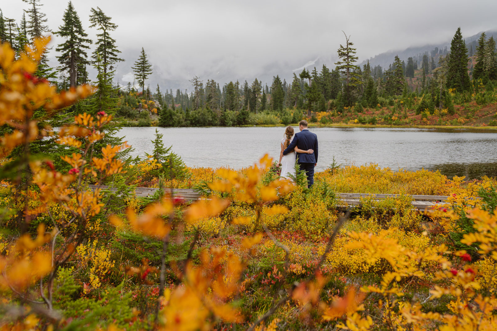 Couple look at Mount Shuksan from Picture Lake during Autumn in Mount Baker Wilderness