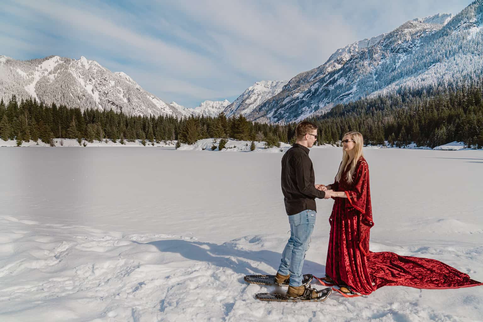 Couple snowshoes to the snowy winter wonderland at Gold Creek Pond on their adventure elopement