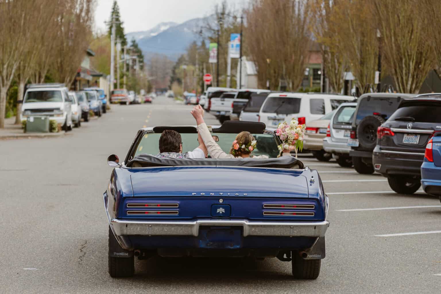Couple enjoys a ride in their favorite classic car on their adventure elopement
