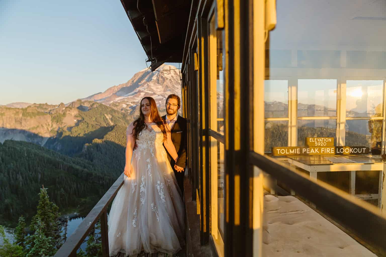 Couple enjoys the view from Tolmie Peak Fire Look in Mount Rainier National Park on their Washington Adventure Elopement