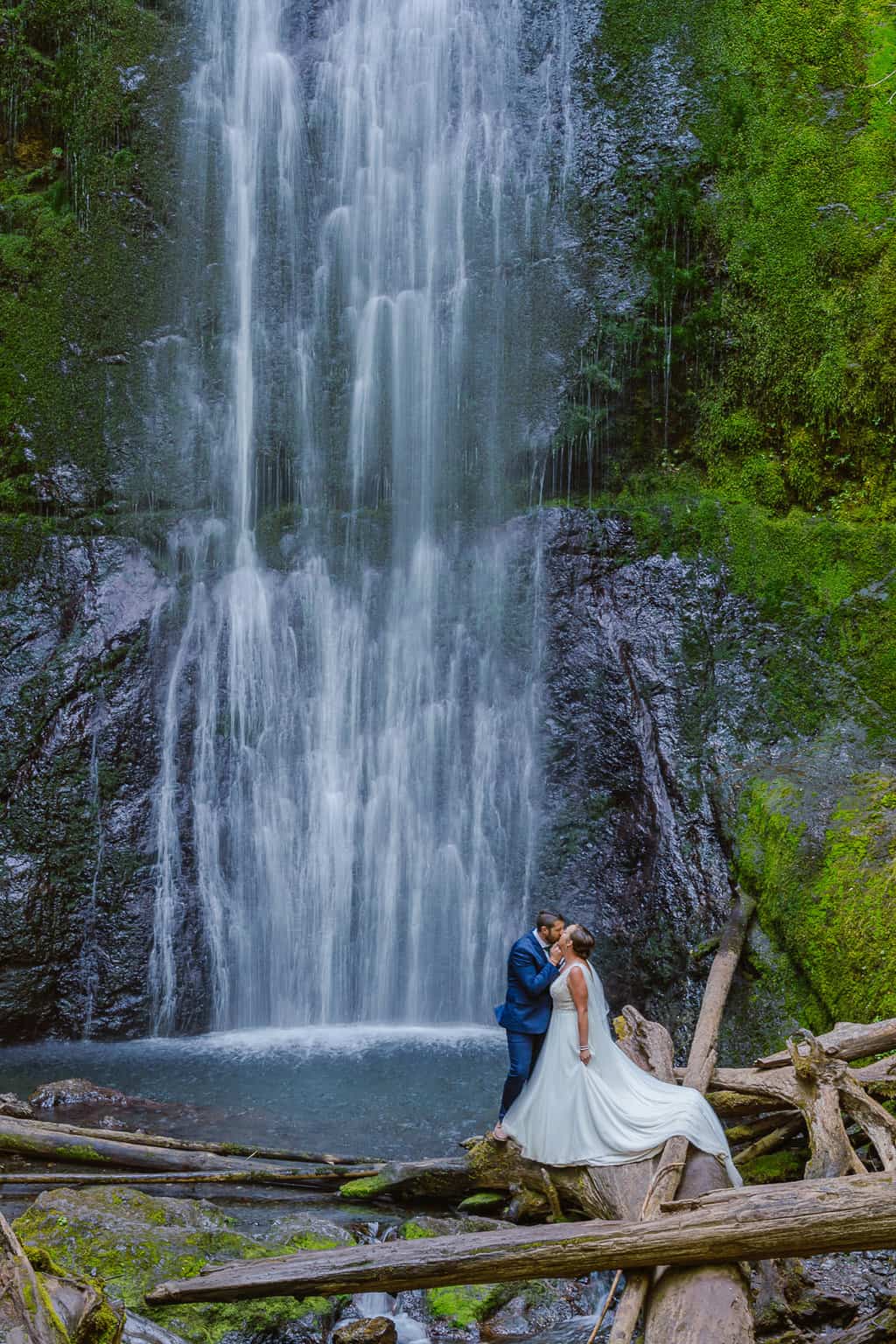 Couple enjoys an adventure at the base of Marymere Falls in Olympic National Park