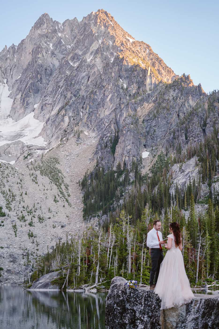 Couple reads elopement vows to each other at Colchuck Lake with Outshined Photography